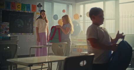 Female Teacher Finishing Lesson, Saying Goodbye to Diverse Kids at the End of School Day. Primary School Girl Packing Her Backpack, Giving Five to Teacher and Leaving School for Holidays. Slow Motion.