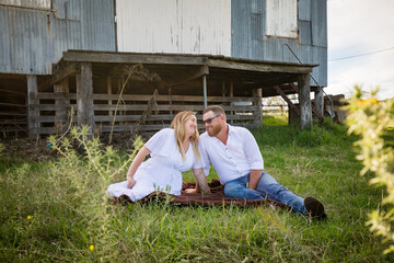Romantic portrait of man and woman sitting together on farm