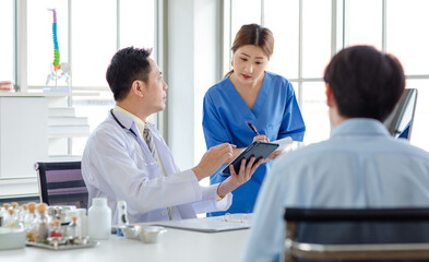 Obraz premium Asian male doctor consulting explaining talking medications to patient sick assisted by caregiver nurse professional support trust healthcare checkup insurance treatment wellness in hospital clinic.