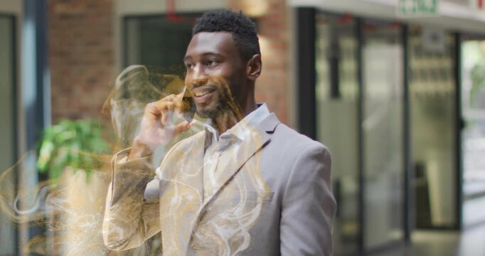Businessman walking in lobby speaking on smartphone starting gold effect on torso reacting to call