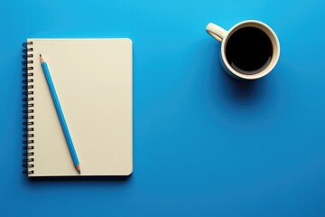Clear Pixel Visual of Coffee Cup,Blank Spiral Notepad and Pen on Blue Office Desk