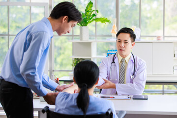 Obraz premium Asian professional doctor consulting senior old female patient with caregiver beside in bright medical office checkup insurance attentively reviews health details providing care support examination 