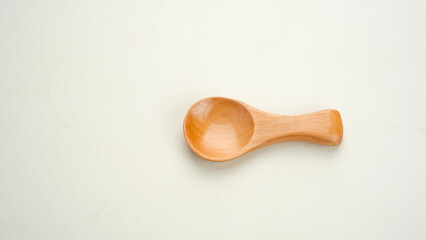 Small wooden spoon on white surface. Copy space.
