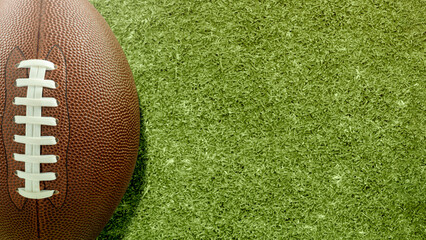 American football ball on the green field of an American football stadium. Concept of sport