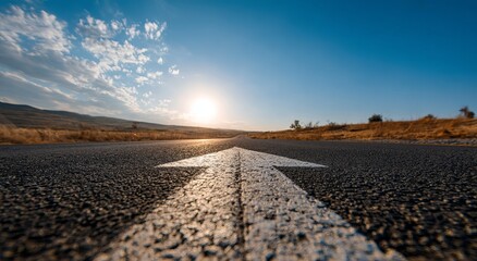 Highway arrow points towards a bright sun