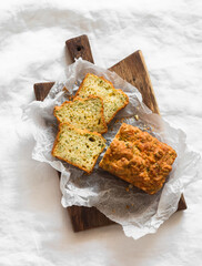 Cheddar cheese, dill, coriander herbs savory cake on a wooden cutting board on light background, top view
