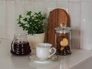 Coffee break - coffee pot, cookie jar, cup of coffee on the kitchen table