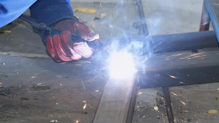 Close Up Of A Hand Welding Metal Structure Using Welding Torch Producing Sparks and Heat - Powered by Adobe