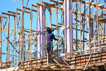 construction worker preparing wooden support structure before pouring concrere beam