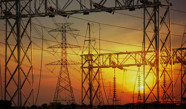 the high voltage electric pole pass in country side to power converter station sunset nature background