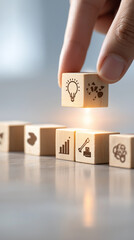 Hand placing wooden block with lightbulb icon above other blocks icons row