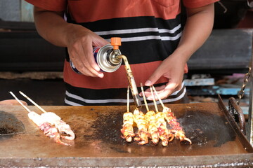 squid satay grilled with a small gas cylinder. seafood. 