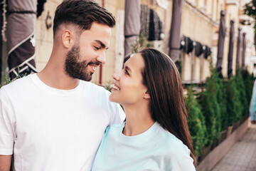Fototapeta premium Smiling beautiful woman and her handsome boyfriend. Woman in casual summer jeans clothes. Happy cheerful family. Female having fun. Sexy couple posing in the street at sunny day