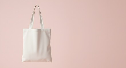 A plain, off-white tote bag suspended against a soft, pastel pink background. totebag, tote bag, tote-bag mockup for design and fashion