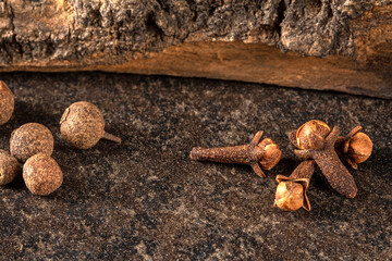 Close-up of colorful peppercorns and cloves on a black background