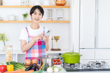 キッチンで献立を考える主婦。