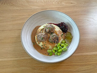 Meatball served with berry jam, vegetables and mashed potato