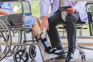Fototapeta premium Close up asian doctor physiotherapy check splint leg support to senior old woman patient assisted by caregiver medical orthopedic trauma treatment team providing rehabilitation in a healthcare clinic.