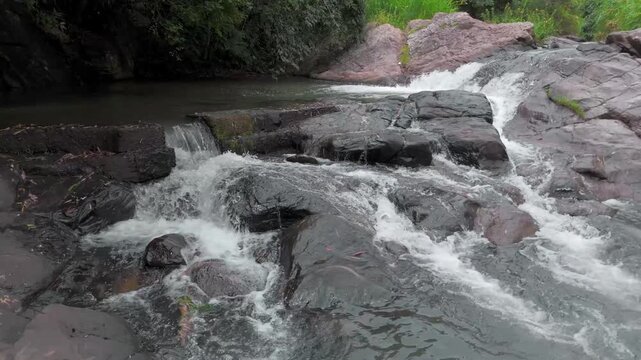Drone Push-In Shot of Small River Flowing Through Rocks in Tropical Forest