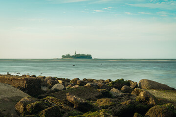 Piedras iluminadas con la isla en el atardecer 