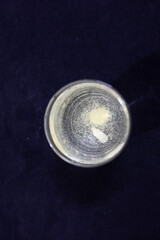 dissolving medicine in transparent glass of water at indoor