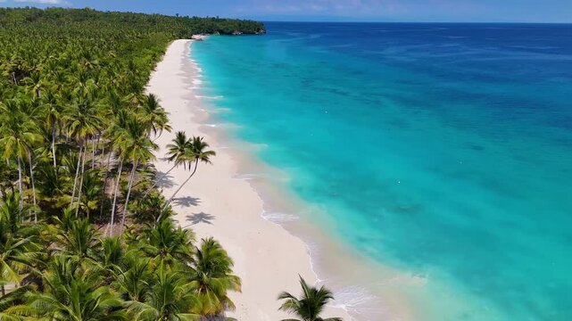 Still 4K drone video of Mandel Beach, a beautiful white sand beach in The Banggai Islands in Suluwesi, Indonesia. You can see the bright blue ocean rolling against the shore of the white sand beach.