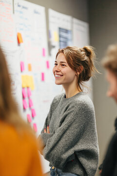 Midmorning in a coworking classroom with a whiteboard full of ideas A facilitator is guiding people through a branding session The mood is thoughtful