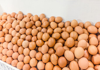 Fresh brown chicken eggs displayed in large quantity at local market. Natural organic farm eggs with varied sizes and speckled shells, healthy protein source for cooking.