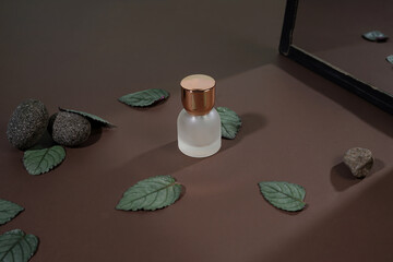 Cosmetic Bottle and Leaves with Natural Stones on a Brown Surface