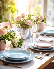 Elegant dining setup with blue plates, crystal glasses, and fresh flowers under warm sunlight for a beautiful meal.