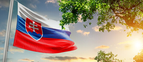 Slovakia national flag waving in the sky behind the tree. The flag blow in beautiful sunlight. Slovakia national flag for independence day.