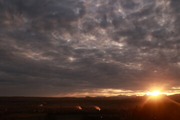 The sky is cloudy and the sun is setting