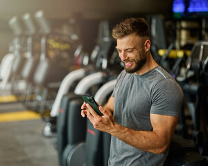 Portrait of a young man using a phone ant exting taking a break exercising in a gym, running using  thereadmill machine equipment, healthy lifestyle and cardio exercise at fitness club concepts