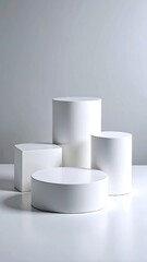 Minimalist composition of four white geometric shapes on a white surface against a light grey background