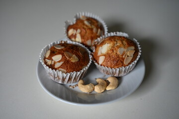 Homemade gluten-free and sugar-free almond muffins made with special flour. Topped with almonds and served with cashew nuts. A healthy, diet-friendly dessert for clean eating.