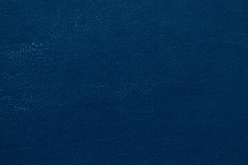 Dark blue faux leather background with cracks and folds texture, close-up of material for upholstery, design