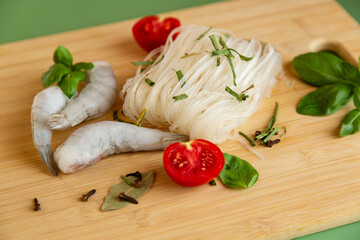 Preparing dinner rice noodles raw shrimp protein and green spices