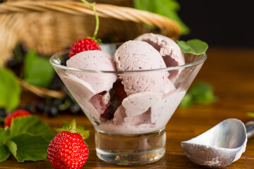 Summer cold dessert with strawberries and blackcurrants on wooden background