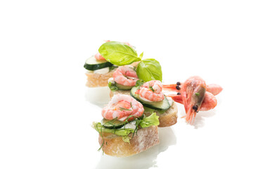 Appetizing appetizers with shrimps, sauce and cucumbers on a white background
