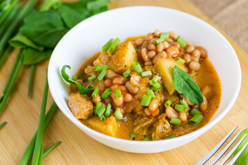 Vegetable stew with meat and potatoes in a white bowl on the table