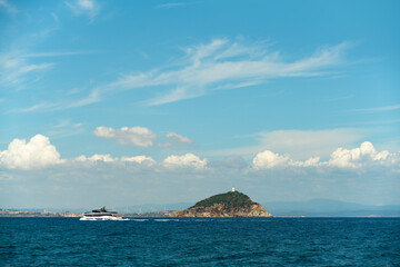 A luxury yacht sailing by a small island