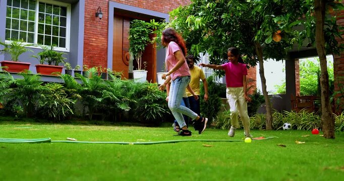 Indian family playing Langdi game in home garden, spending quality fun time together enjoying outdoor sports, hopping on one leg in traditional Indian team game that combines tag agility-based play