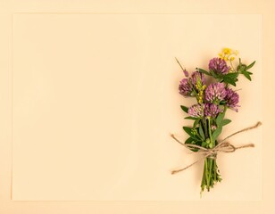 Obraz premium Wildflower Bouquet Tied With Jute String Against Soft Beige Blank Background