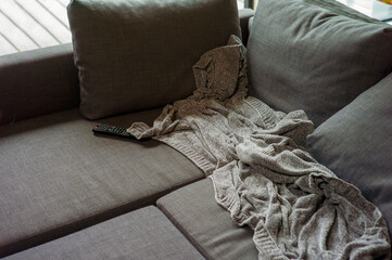 couch with a crumpled blanket