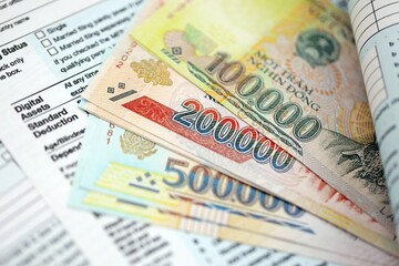 Vietnamese dong money bills on tax form. Taxation and accounting concept