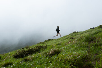 Bright collage of male athlete running uphill on misty green mountain slope. Concept of endurance branding, eco trail ads, motivational posters, wellness lifestyle content. © master1305