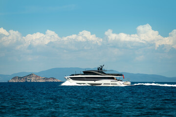 A luxury yacht sailing in the open sea near an island