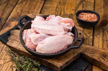 Juicy uncooked chicken wings, a versatile ingredient perfect for frying, baking, or grilling to perfection. wooden background. top view