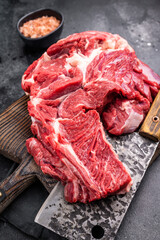 Beautifully marbled raw beef neck meat, perfect for enhancing your favorite recipes with rich flavors. black background. top view