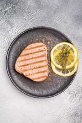 Deliciously charred grilled tuna steak, served with fresh herbs, a healthy and flavorful choice for any meal. white background. top view